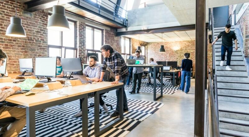 Two developers reviewing AI chatbot logic on a monitor